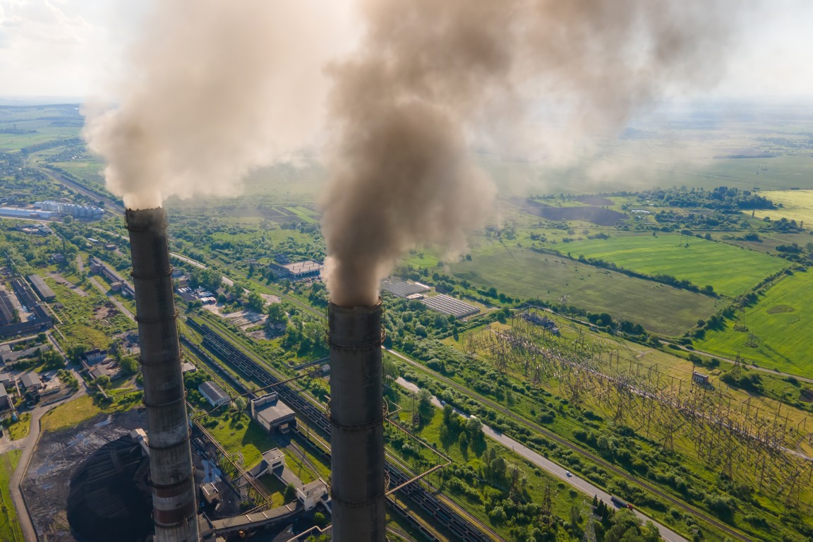 Aerial view of coal power plant high pipes with black smokestack