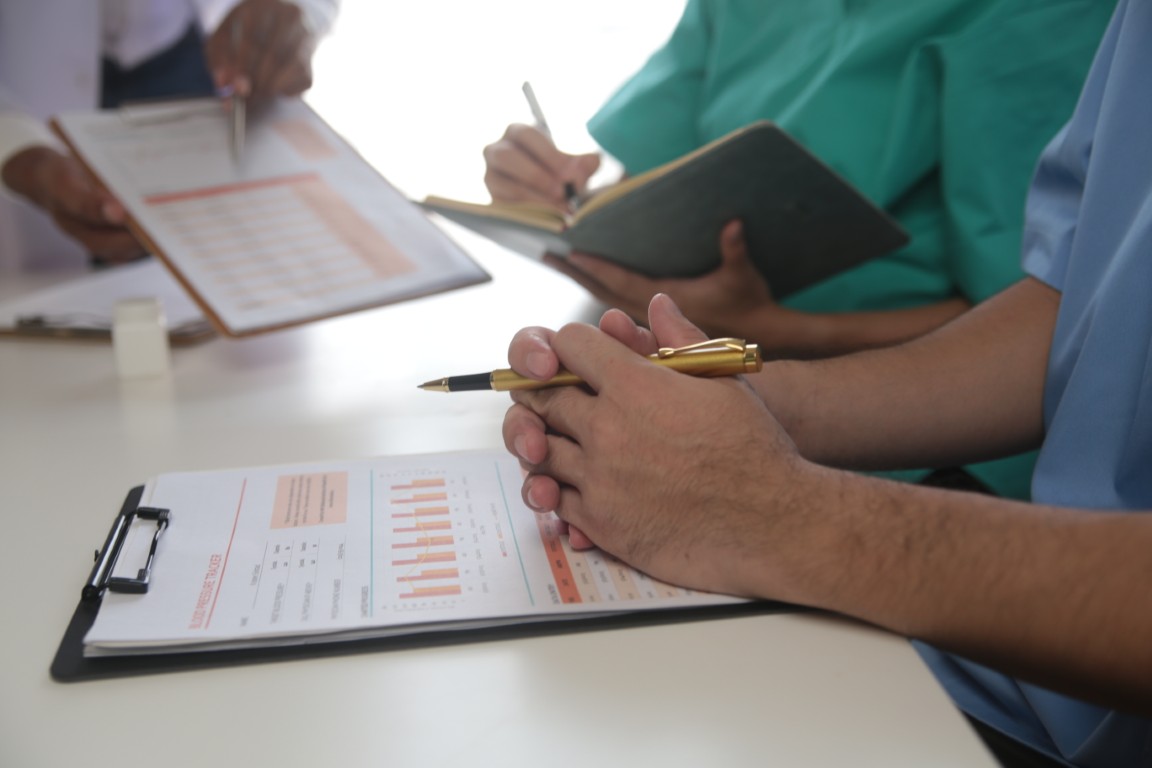 Medical Team Meeting Around Table In Modern Hospital