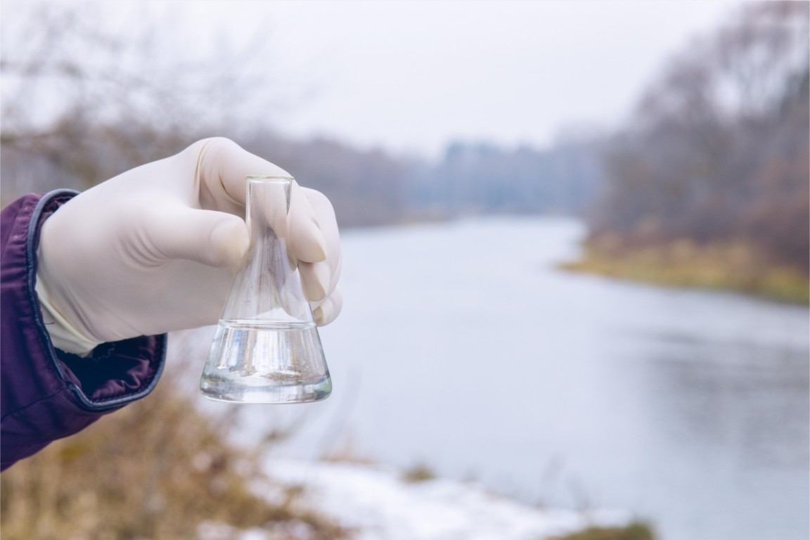 Person holding flask with blue label that says water it